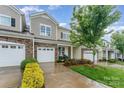 Well-maintained townhome with a stone facade, attached garage, and lush landscaping in a desirable neighborhood at 829 River Park Rd, Belmont, NC 28012
