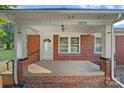 Inviting brick front porch featuring classic columns and a white front door at 1000 Peachtree Rd, Charlotte, NC 28216