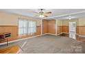 Comfortable living room with vintage paneled walls, ceiling fan, and generous natural light at 1000 Peachtree Rd, Charlotte, NC 28216