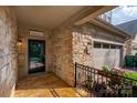 Covered front entrance with stone accents, black front door, 'Welcome' sign and iron railing details at 10502 Old Ardrey Kell Rd, Charlotte, NC 28277
