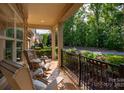 Inviting front porch with comfortable seating, manicured landscaping, iron railings and plenty of natural light at 10502 Old Ardrey Kell Rd, Charlotte, NC 28277