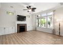 Bright living room with a decorative ceiling fan, fireplace, built-in cabinets and large windows for natural light at 10502 Old Ardrey Kell Rd, Charlotte, NC 28277
