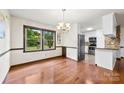 Bright dining area featuring hardwood floors, a chandelier, and a large window at 113 Helena St, Mount Holly, NC 28120