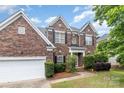Beautiful two-story brick home featuring an attached two-car garage and a well-manicured lawn at 11526 Mcginns Trace Ct, Charlotte, NC 28277