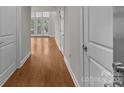 Inviting hallway showcasing sleek hardwood floors and neutral wall tones with multiple doors at 120F Steinbeck Way, Mooresville, NC 28117