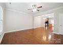 Spacious living room with hardwood floors, a ceiling fan, and an open layout into the kitchen at 13358 Calloway Glen Dr, Charlotte, NC 28273