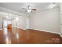 Bright living room showcasing hardwood floors, neutral walls, and an open layout to the kitchen and stairs at 13358 Calloway Glen Dr, Charlotte, NC 28273
