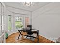 Bright home office with hardwood floors, bay window, and a modern black desk at 1402 Coachman Dr, Waxhaw, NC 28173