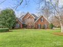 Traditional brick home boasts a lush lawn and well-maintained landscaping at 3115 Duck Point Dr, Monroe, NC 28110