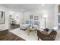 Bright living room with white brick walls, wood floors, and a comfortable seating arrangement at 4226 Randolph Rd, Charlotte, NC 28211