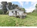 Rear exterior view of home with a wooden deck, stairs, and a spacious lawn at 6124 Old Mt Holly Rd, Charlotte, NC 28208
