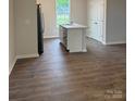 Modern kitchen featuring an island with stainless steel sink and elegant wood flooring at 7 Scott Sw St, Concord, NC 28025