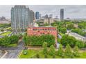 A red brick apartment building is nestled among greenery with downtown buildings in the background at 715 N Church St # 613, Charlotte, NC 28202