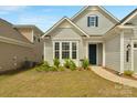 Well-kept front yard with flowering shrubs and healthy green grass leads to a home with blue shutters at 7332 Jolly Brook Dr, Charlotte, NC 28215