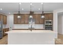 Bright kitchen featuring stainless steel appliances, custom cabinets, a gas cooktop, and a large island at 7332 Jolly Brook Dr, Charlotte, NC 28215