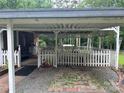 Covered carport with white picket fence, offering protected parking at 8524 Anette Ave, Mint Hill, NC 28227