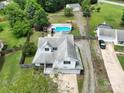 Aerial view showcasing a well-maintained property with a blue pool, a wooden deck, and mature landscaping at 8540 Indian Summer Trl, Harrisburg, NC 28075