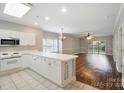 Bright kitchen featuring white cabinets, long countertops, and an open layout to the living area at 8731 Coralbell Ln, Charlotte, NC 28213