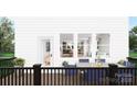 Back porch with a table set for dining overlooking views into the home's kitchen, dining and living spaces at 917 Archway Ln, Charlotte, NC 28217