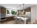 Modern kitchen with a center island, pendant lighting, stainless steel appliances, and a large window at 917 Archway Ln, Charlotte, NC 28217