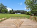 Spacious wooden deck with built in seating and a view of the backyard and shed at 1028 Swaying Oats Dr, York, SC 29745
