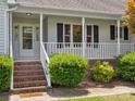 Inviting front porch with brick steps and white railings and manicured shrubs at 1028 Swaying Oats Dr, York, SC 29745