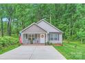 Inviting single-story home featuring a cozy front porch with rocking chairs, a pristine walkway, and a patriotic US flag at 105 W 17Th St, Salisbury, NC 28144