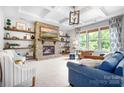 Cozy living room featuring a stone fireplace, open shelves, coffered ceiling, and abundant natural light at 10911 Skymont Dr, Huntersville, NC 28078