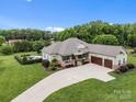An aerial view of a home with a long driveway, lush landscaping, and an in-ground pool at 1115 Wynnbrook Way, Concord, NC 28027