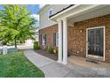 Brick townhome entrance with manicured landscaping and walkway at 11209 Lazio Ln # 1, Charlotte, NC 28277