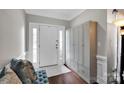 Bright entryway with hardwood floors, a storage bench, and a white front door with sidelights at 12416 Kane Alexander Dr, Huntersville, NC 28078