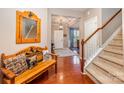 Warm foyer with hardwood floors, staircase, and decorative wooden bench at 12832 Heath Grove Dr, Huntersville, NC 28078