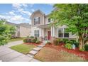 Beautiful two-story home showcasing a well-manicured lawn, a red front door, and an inviting entrance at 12832 Heath Grove Dr, Huntersville, NC 28078