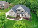 Stunning aerial view of the brick home with lush greenery surrounding the property at 129 Overlook Ridge Ln, Davidson, NC 28036