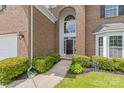 Inviting brick home entrance with arched window and manicured landscaping at 14104 Kendrick Cross Rd, Charlotte, NC 28273
