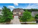 Charming two-story home with brick and beige siding, mature trees, and inviting curb appeal at 14316 Baytown Ct, Charlotte, NC 28078