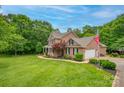 Traditional brick home with a two-car garage, manicured lawn, and mature trees at 144 Chickasaw Dr, Shelby, NC 28152