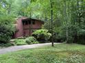 Beautiful two-story home with unique design surrounded by lush greenery and mature trees at 1451 Blueberry Ln, Charlotte, NC 28226