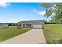 Single-story house featuring a well-maintained lawn and a long driveway leading to an attached garage at 154 Stable Brook Ln, Taylorsville, NC 28681