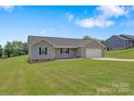 Charming single-story house featuring a well-maintained lawn and a long driveway to an attached garage at 154 Stable Brook Ln, Taylorsville, NC 28681