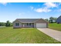 Single-story house featuring a well-maintained lawn and a long driveway leading to an attached garage at 154 Stable Brook Ln, Taylorsville, NC 28681