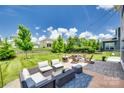 Inviting backyard patio featuring cozy seating, a fire pit, and a beautifully landscaped lawn for outdoor enjoyment at 16008 Weeping Valley Dr, Fort Mill, SC 29715