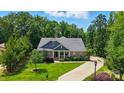 A beautiful, well-maintained home with a long driveway and mature trees, nestled in a serene setting at 161 Leaning Tower Dr, Mooresville, NC 28117