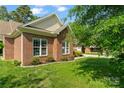 Brick home exterior featuring manicured lawn, trimmed bushes, and bright windows, providing great curb appeal at 2016 Townview Dr, Kannapolis, NC 28081