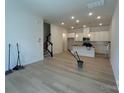 Bright, open-concept living space with hardwood floors leading to the modern kitchen at 3119 Beacon Heights Rd, Indian Land, SC 29707