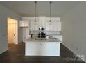 Bright kitchen featuring a large island, white cabinetry, stainless steel appliances, and pendant lighting at 3125 Beacon Heights Rd, Indian Land, SC 29707