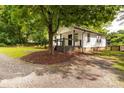 Exterior view showing a well maintained white sided home with gravel drive and mature trees at 315 Rivers St, Rock Hill, SC 29730