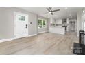 Bright, open-concept living room features modern flooring and leads to a kitchen with white cabinets at 3920 Admiral Ave, Charlotte, NC 28205