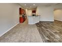 Modern kitchen open to living area, featuring stainless steel appliances and breakfast bar at 4006 Lawrence Daniel Dr, Matthews, NC 28104