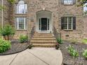Charming brick home entrance with decorative landscaping and elegant wrought iron railings at 410 Deer Brush Ln, Waxhaw, NC 28173